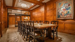 A dining room with a long wooden table, multiple chairs, and a chandelier. - O.Henry Hotel (Greensboro)