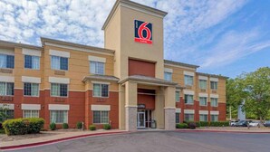 A 6 Suites hotel with a central lobby entrance, multiple floors, and a parking lot. - Studio 6 Extended Stay Memphis Airport TN (Memphis)