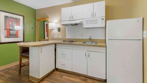 A compact kitchen with white cabinets, a microwave, and a refrigerator. - Extended Stay America Select Suites - Washington, DC - Sterling - Dulles (Sterling)