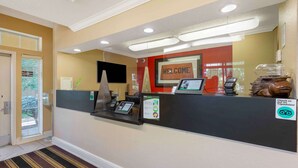 A reception area with a 'WELCOME' sign, a digital kiosk, a coffee station, and a TripAdvisor sign. - Extended Stay America Select Suites - Washington, DC - Sterling - Dulles (Sterling)
