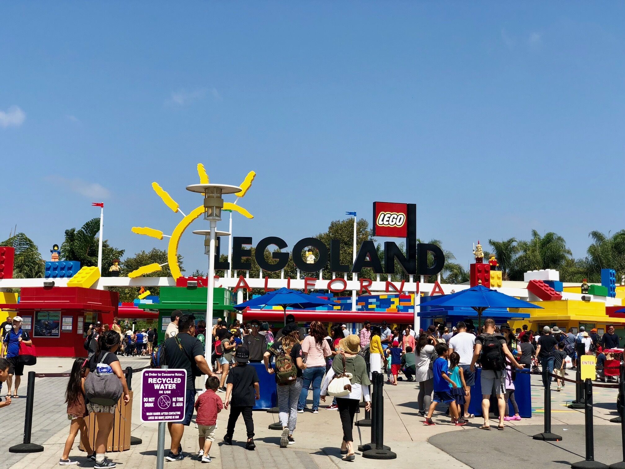 A busy entrance area with a prominent LEGO sign, indicating a themed attraction or event.