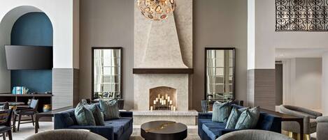 A modern living room with a fireplace, sofas, and a unique chandelier.
