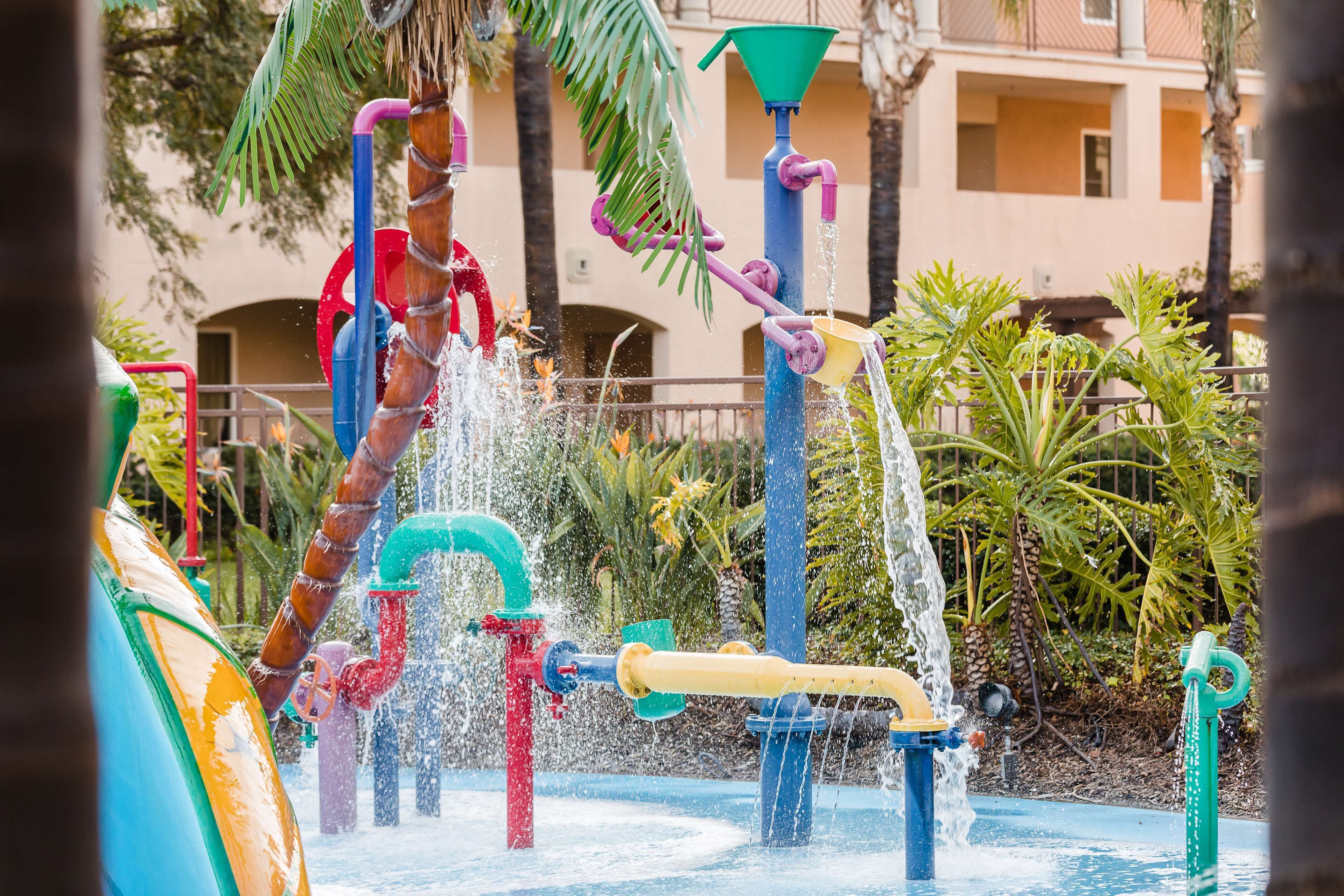 A water play area with multiple water jets and a colorful slide.