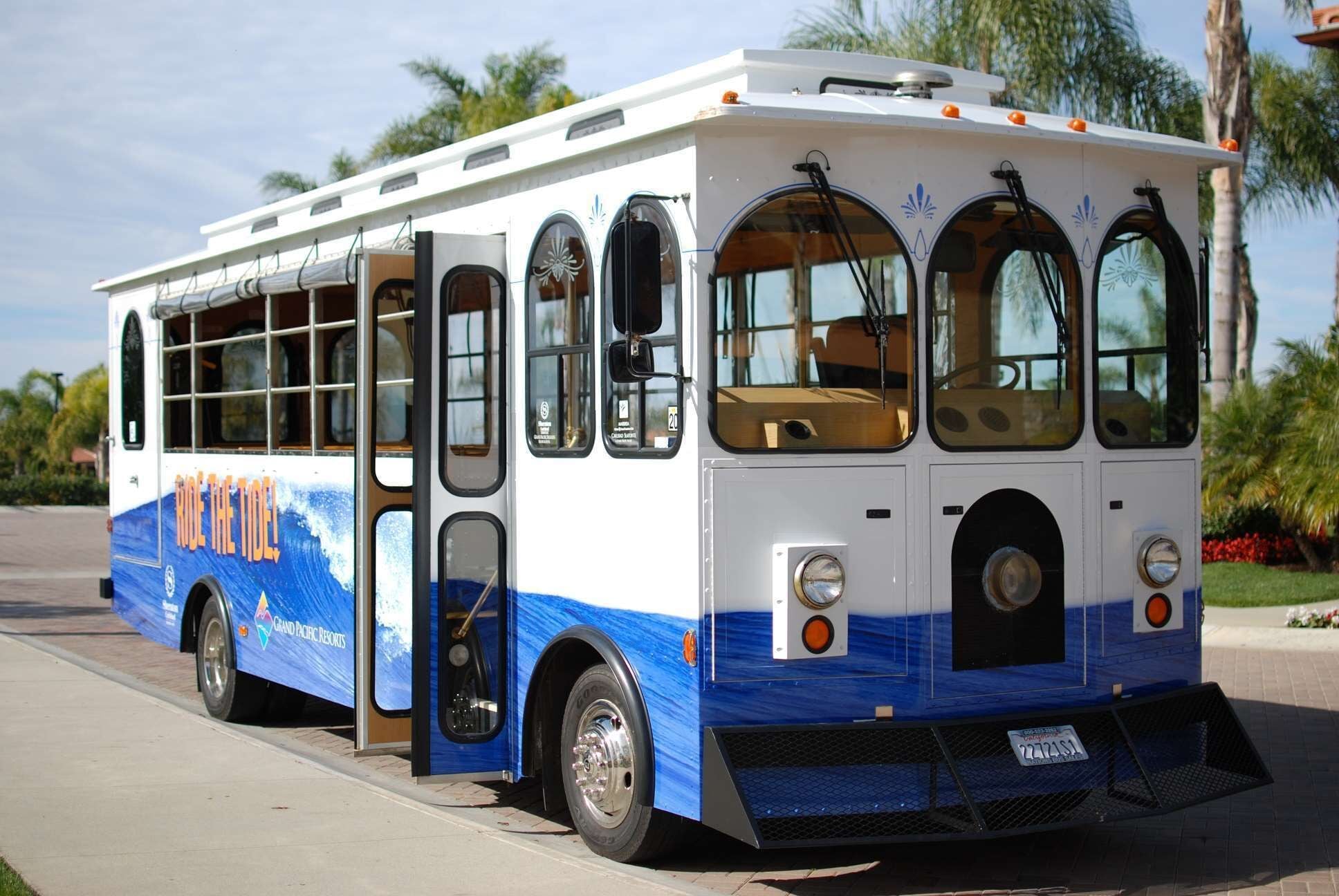 Un autobus aux couleurs bleu et blanc, doté de grandes fenêtres et d’une porte à l’avant.