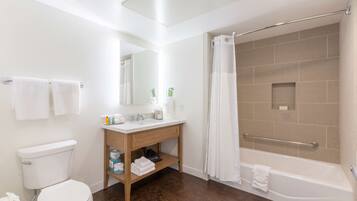 A bathroom with a toilet, sink, vanity, shower, and bathtub.