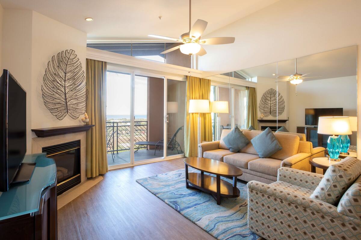 A modern living room with a fireplace, a sofa set, a coffee table, and a television.