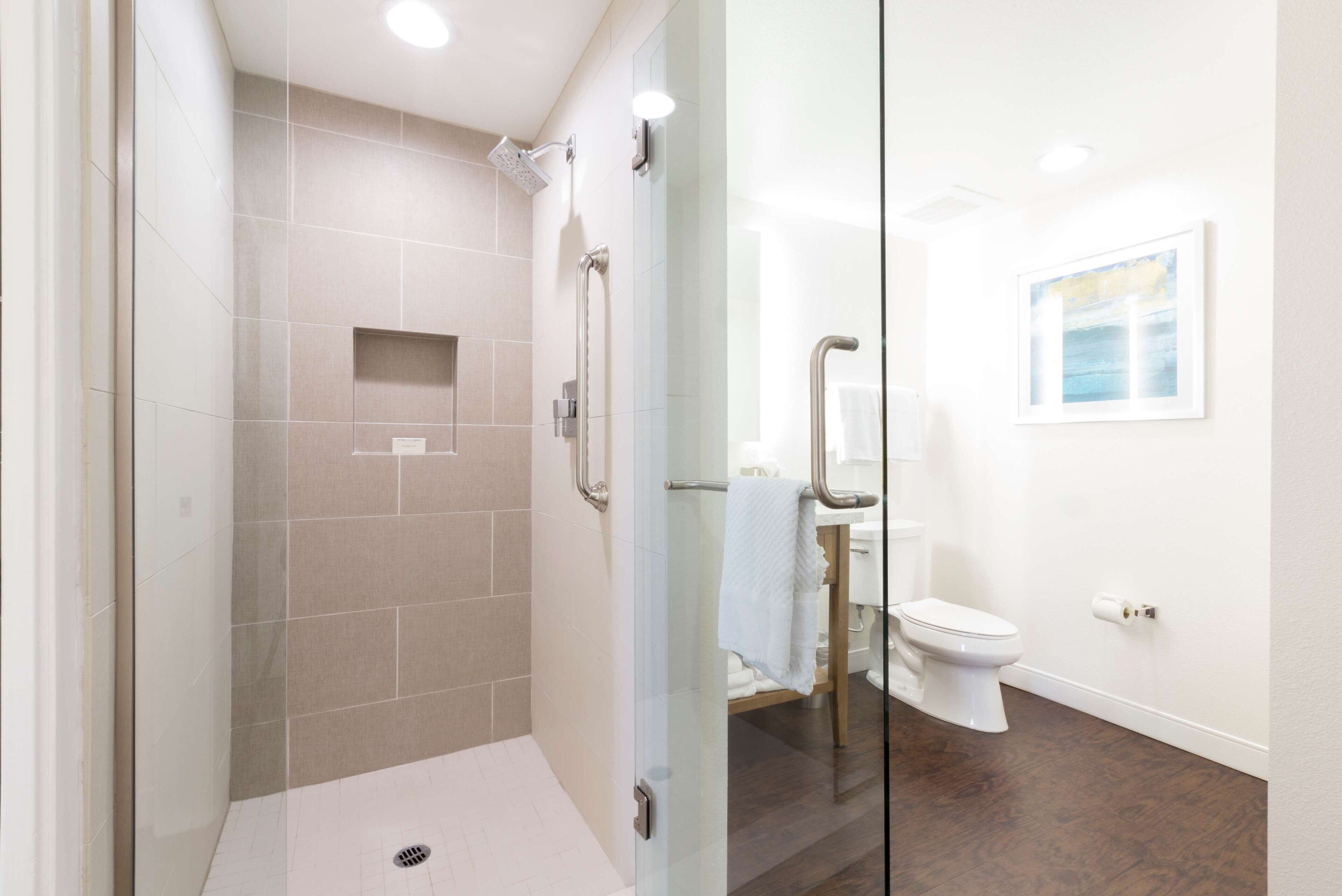 Une salle de bain moderne avec une douche à parois de verre, des toilettes et un lavabo.