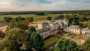A large castle with a courtyard, surrounded by lush greenery and fields. - Hazlewood Castle & Spa (Tadcaster)