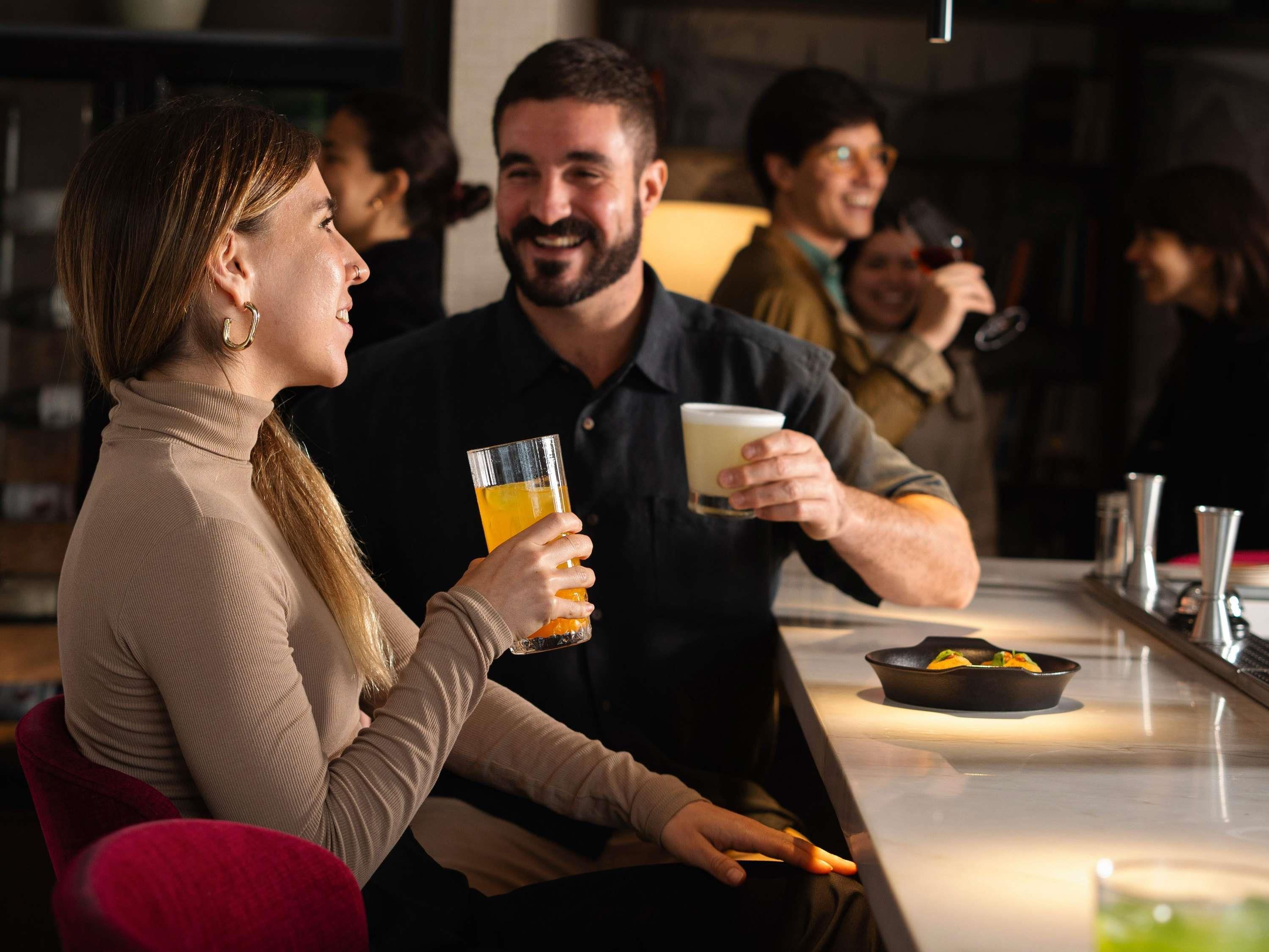 A bar area with a counter, glasses, and a bowl of food.