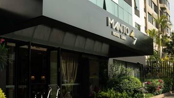 Una entrada de hotel moderna con un letrero que dice 'IMANTO HOTEL LIMA'.
