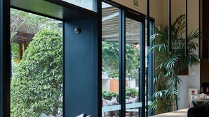 A modern interior with a large window, a seating area with cushions, and a marble counter. - Manto Hotel Lima - MGallery  Collection (Lima)