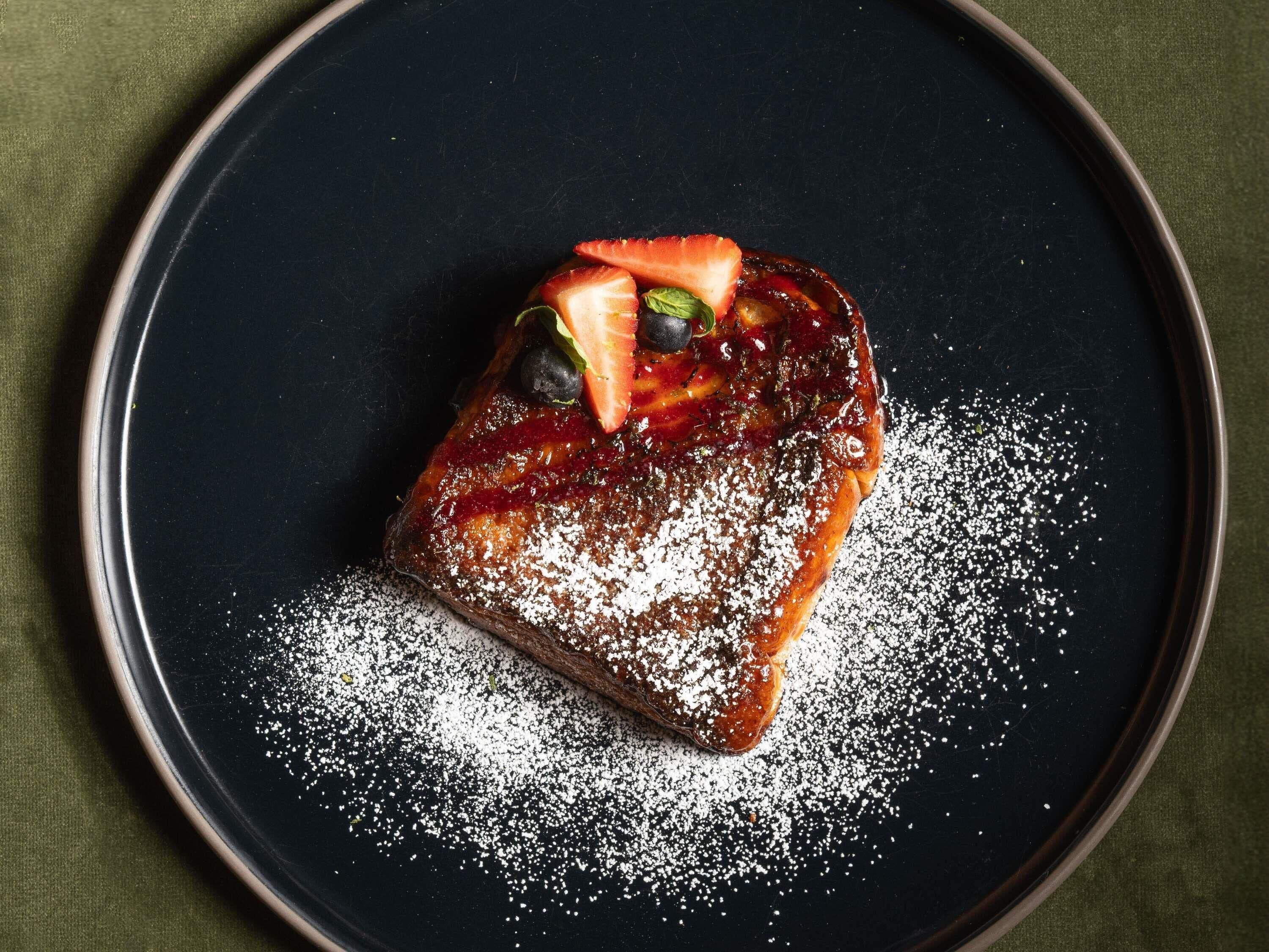 A dessert on a plate with powdered sugar.