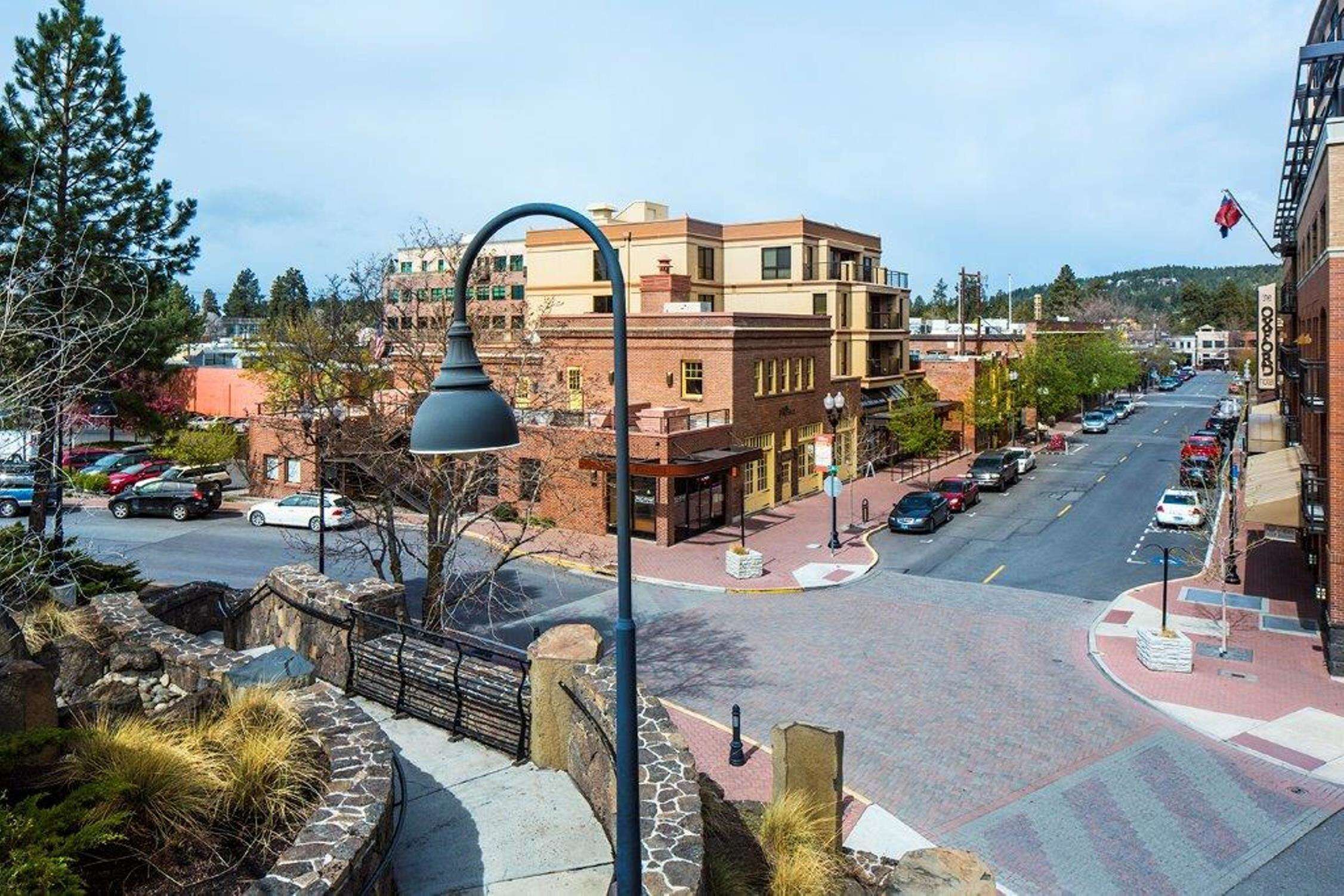 A street view with a mix of modern and traditional buildings, a clear road, and a pedestrian crossing.
