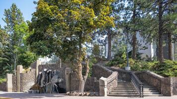A stone staircase leading up to a building, surrounded by trees and greenery.