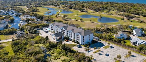 Oversigtsbillede af et resort med flere bygninger, en golfbane og en lysthavn.