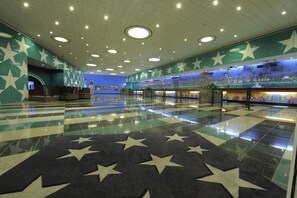 A spacious lobby with a star-patterned floor, a seating area, and a mural on the wall. - Disney's All-Star Movies Resort (Lake Buena Vista)