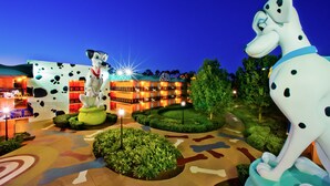 Un hotel con facciata a tema dalmata, diversi balconi e un giardino curato.