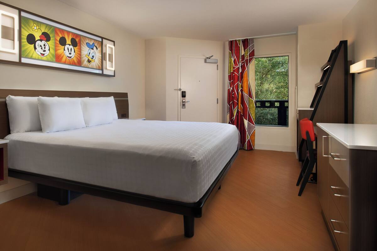 Une chambre d’hôtel avec un lit, une table de chevet et une fenêtre avec des rideaux.