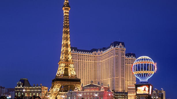 La Tour Eiffel et un grand hôtel à l’avant-plan, dont la structure est surmontée d’un dôme.