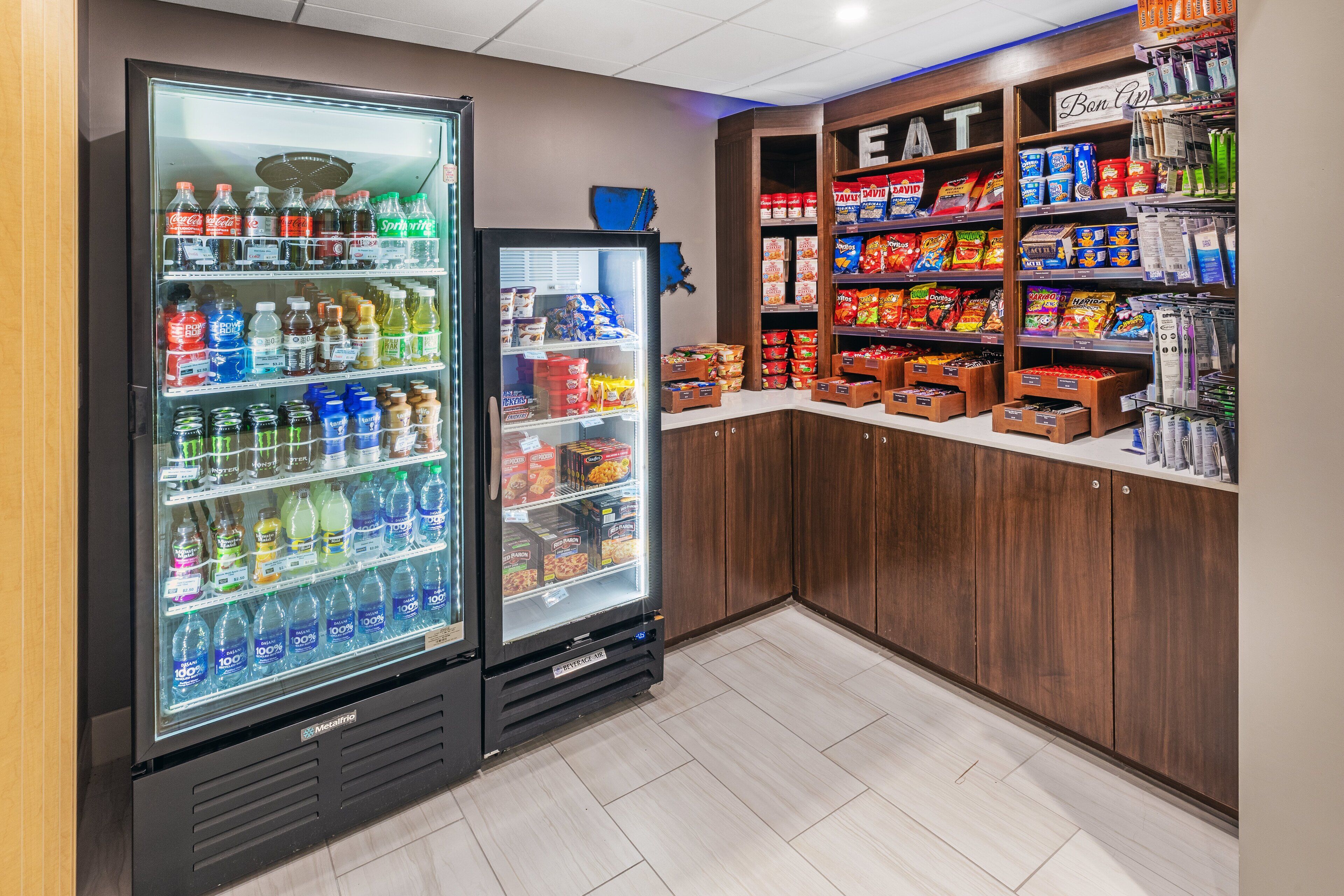 A vending area with two beverage dispensers and a snack shelf.