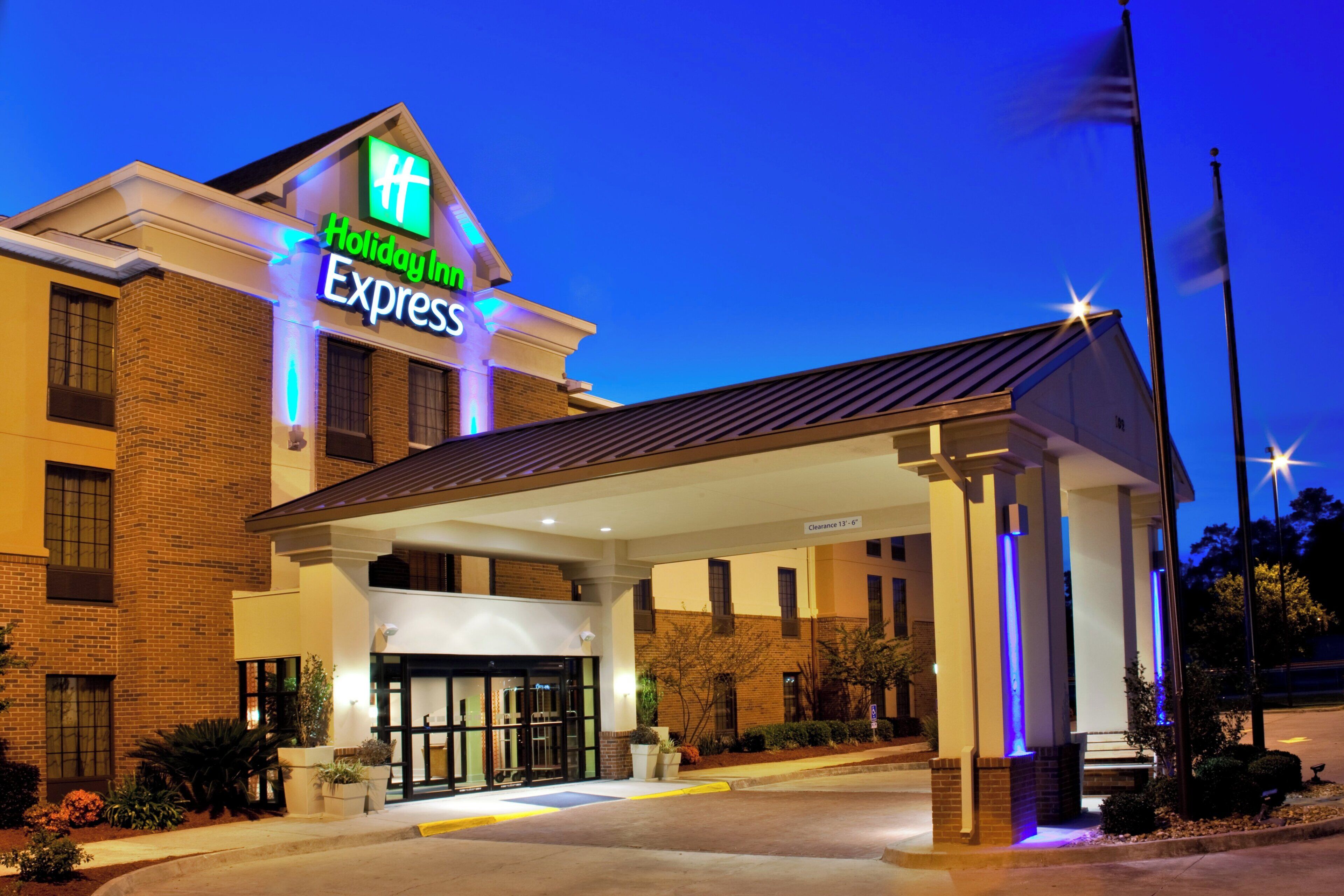 A Holiday Inn Express building with a covered entrance and a clear sky.