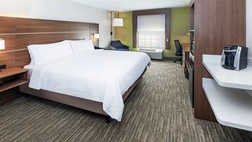 Une chambre d’hôtel avec un grand lit, un bureau, une chaise, un minibar et une fenêtre.