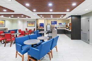 A modern restaurant with blue and red seating, a counter area, and a visible menu board.