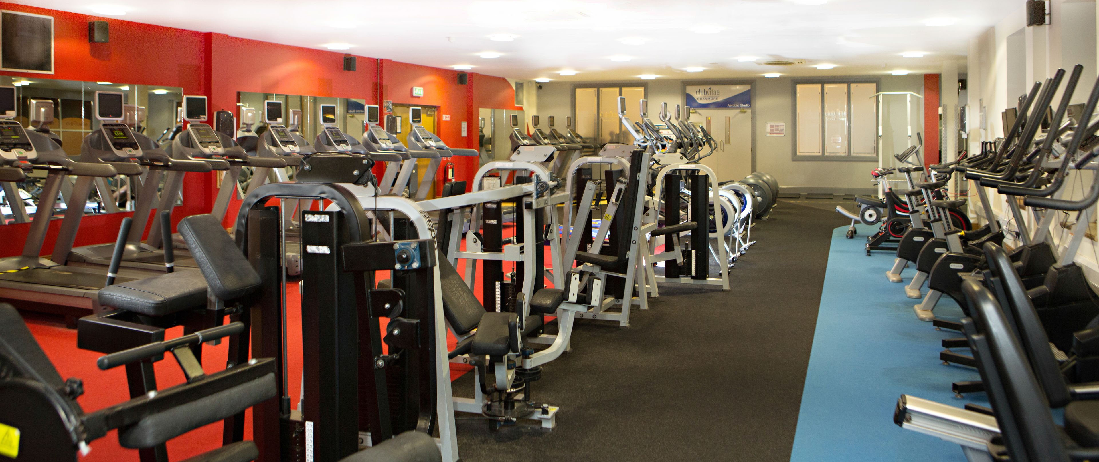 A gym with treadmills, weight machines, and exercise balls.