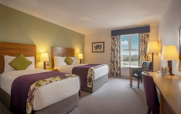 A hotel room with two beds, a desk, a chair, and a window with a view. - Maldron Hotel, Oranmore Galway (Oranmore)