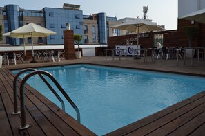 Piscine extérieure, parasols de plage, chaises longues