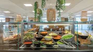 Een buffet met diverse soorten eten en hangende planten.