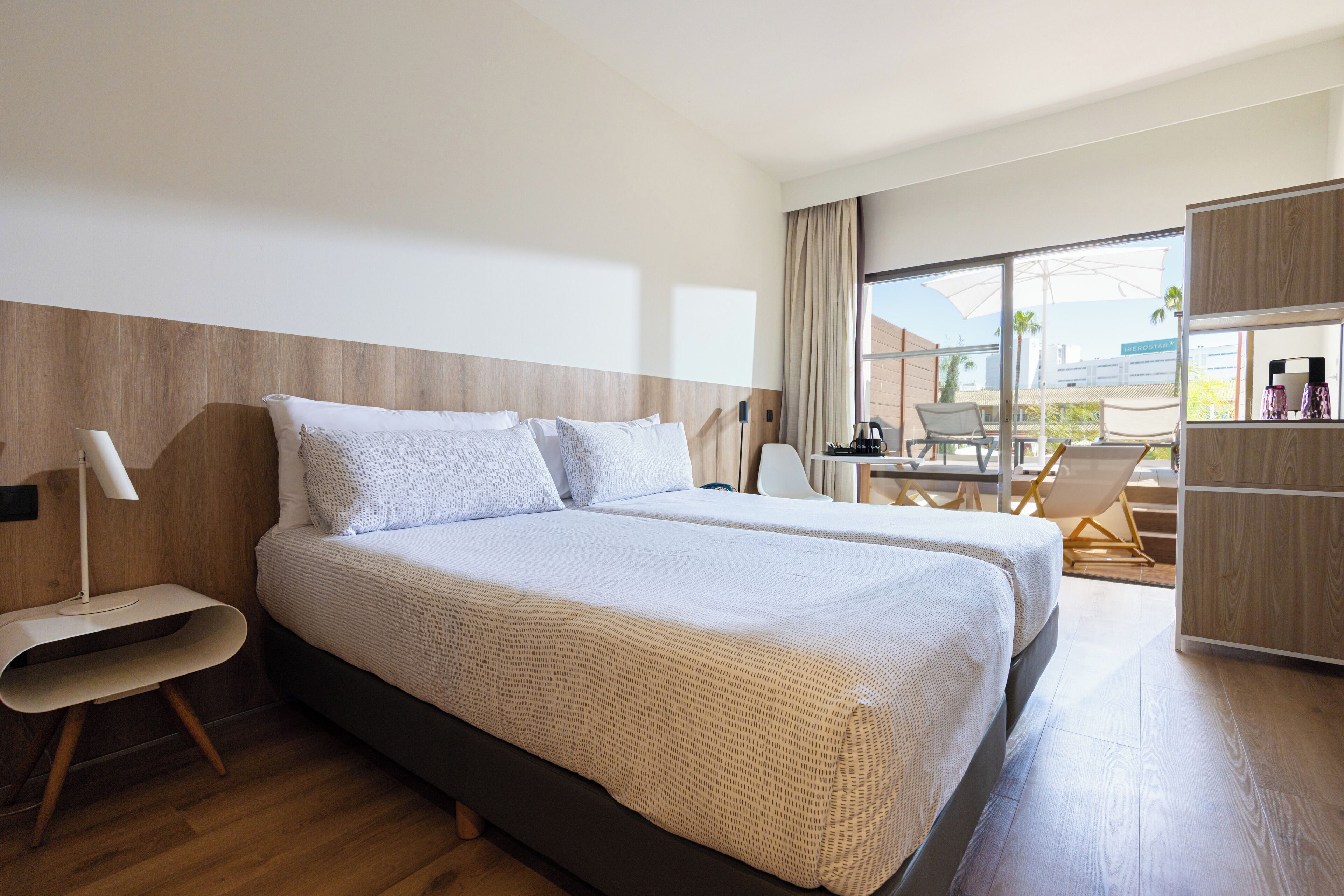Une chambre d’hôtel moderne avec un grand lit, un bureau et une vue sur l’extérieur.
