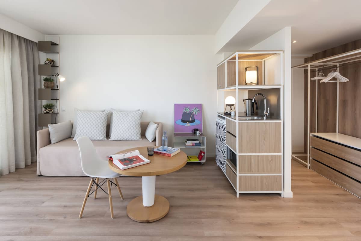 A modern living room with a sofa, a round table, and a bookshelf.