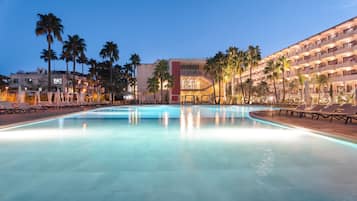 Una piscina al aire libre de temporada, sombrillas