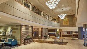 A spacious lobby with a reception desk, seating area, and a staircase connecting two floors. - Southern Sun Cape Town Waterfront (Cape Town)