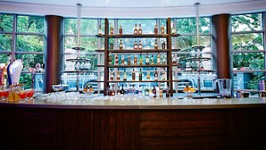 A bar area with shelves of liquor bottles, glasses, and a fruit bowl. - Southern Sun Cape Town Waterfront (Cape Town)