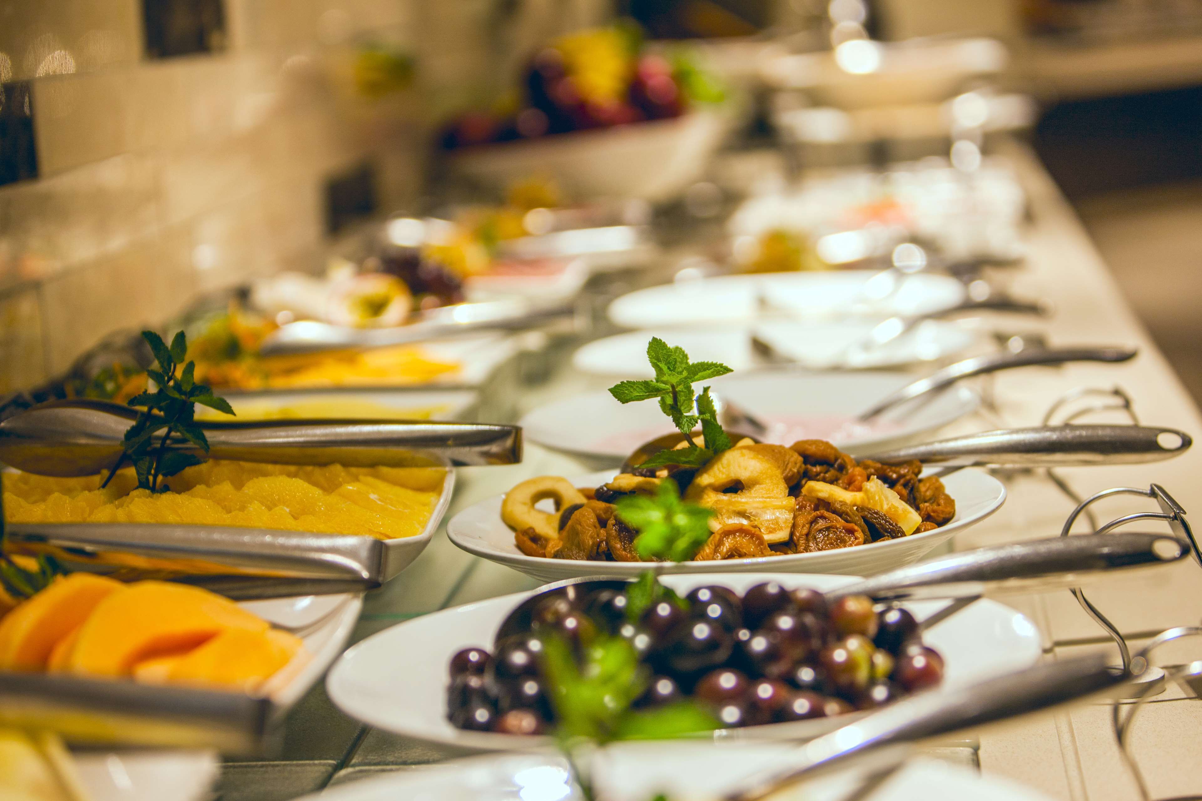 A buffet with various dishes and utensils.