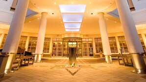 A modern hotel entrance with a curved facade, large columns, and a central skylight. - Southern Sun Cape Town Waterfront (Cape Town)