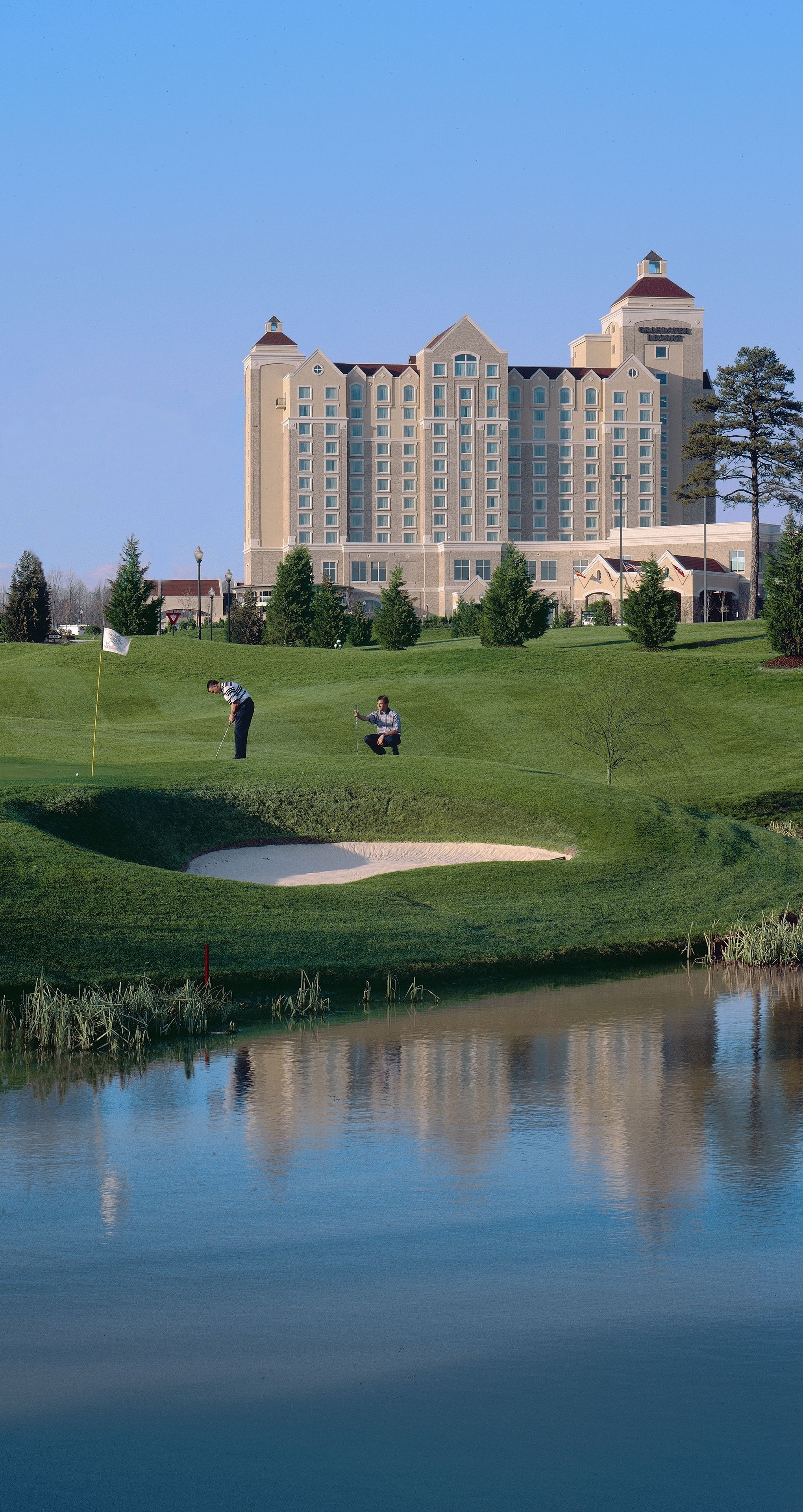 A golf course with a large building in the background.