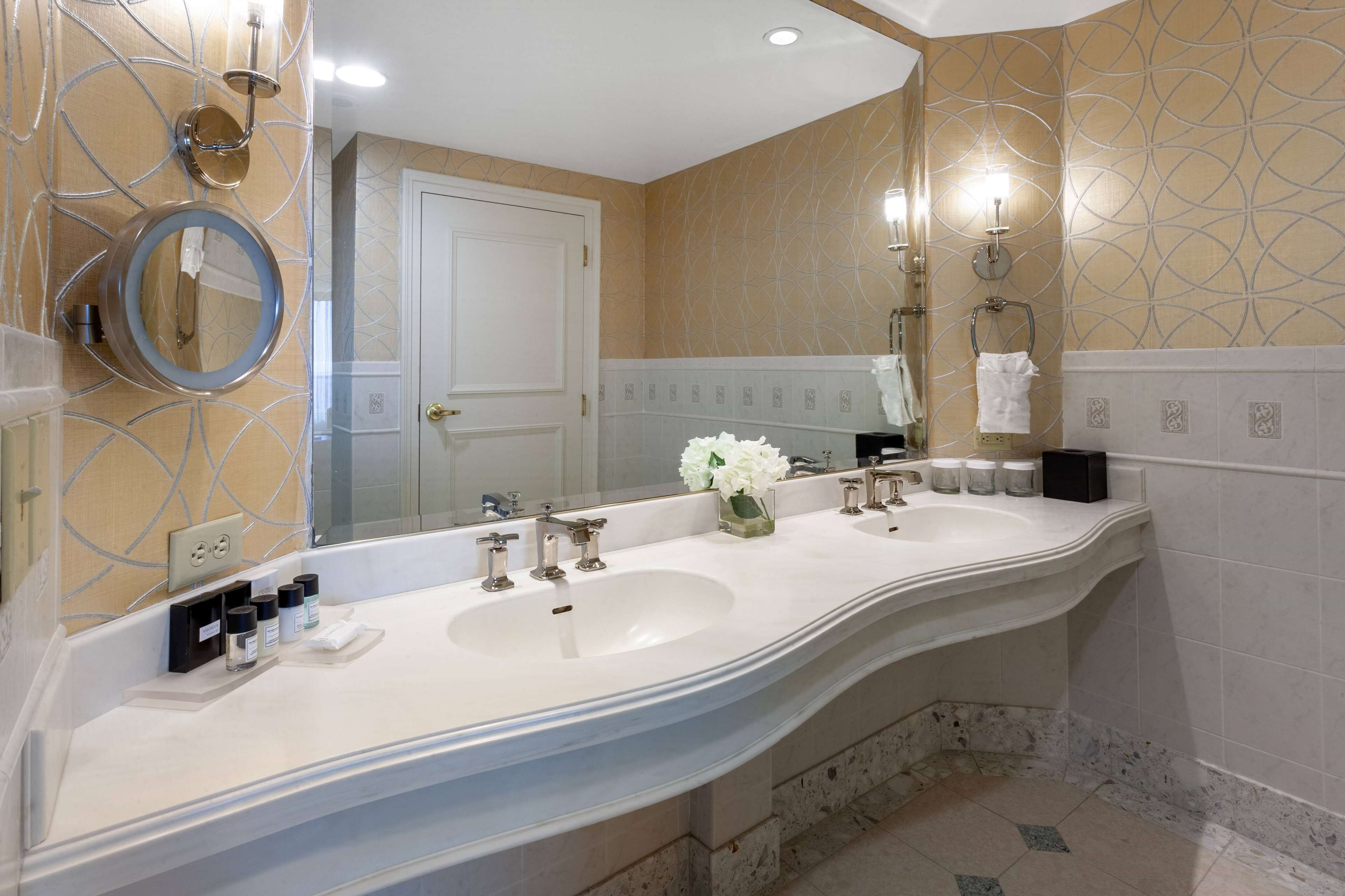 A bathroom with two sinks, a large mirror, and a towel rack.