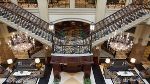 A grand lobby with a central staircase, multiple seating areas, and a chandelier. - Grandover Resort & Spa, a Wyndham Grand Hotel (Greensboro)