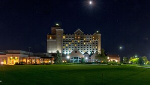 A large, multi-story hotel with a prominent tower and a well-lit facade. - Grandover Resort & Spa, a Wyndham Grand Hotel (Greensboro)
