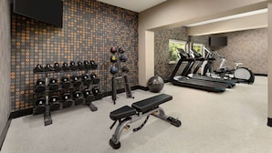 A gym with treadmills, stationary bikes, dumbbells, and a bench. - La Quinta Inn & Suites by Wyndham Salem OR (Salem)