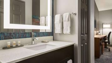 Un baño moderno con un espejo grande, un lavabo y un perchero para toallas.