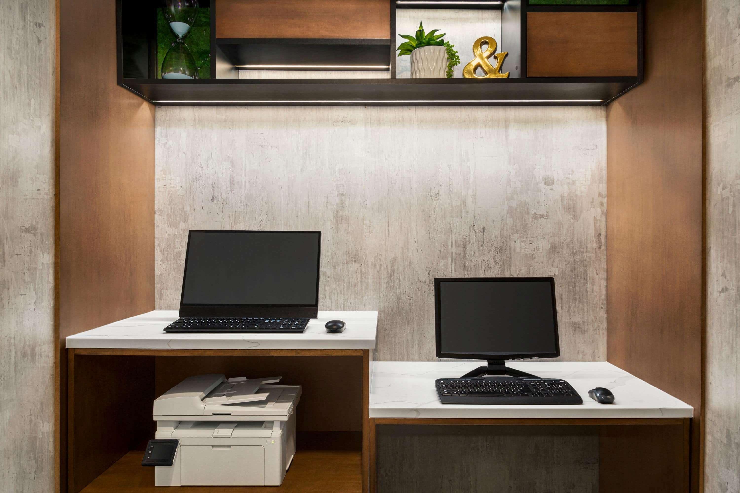 Two desks with computers, each with a printer.