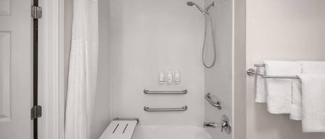 A modern bathroom with a shower, a bathtub, a towel rack, and a toilet paper holder.