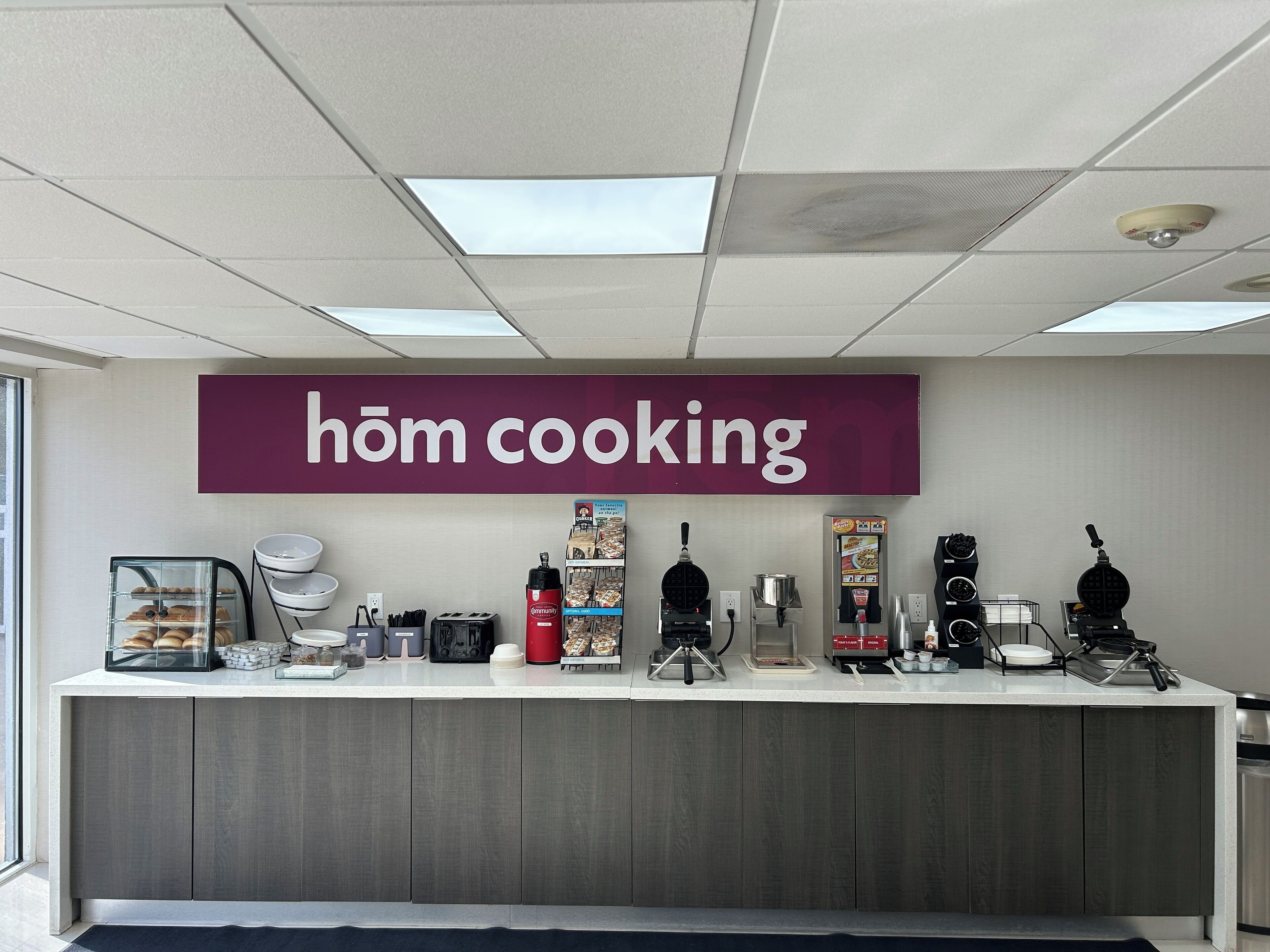 A kitchen counter with a sign reading 'hôm cooking' and various cooking appliances.