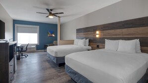 A hotel room with two beds, a ceiling fan, a TV, and a desk with a chair. - HOM Hotel Gainesville, SureStay Collection by Best Western (Gainesville)