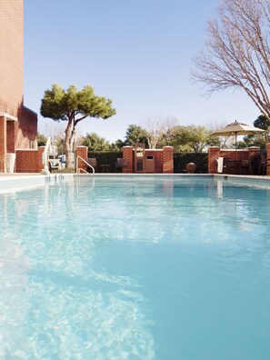 Una piscina al aire libre, sombrillas