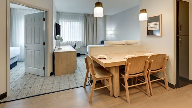 Une chambre d’hôtel comprenant un coin repas, un lit, un bureau et une armoire.